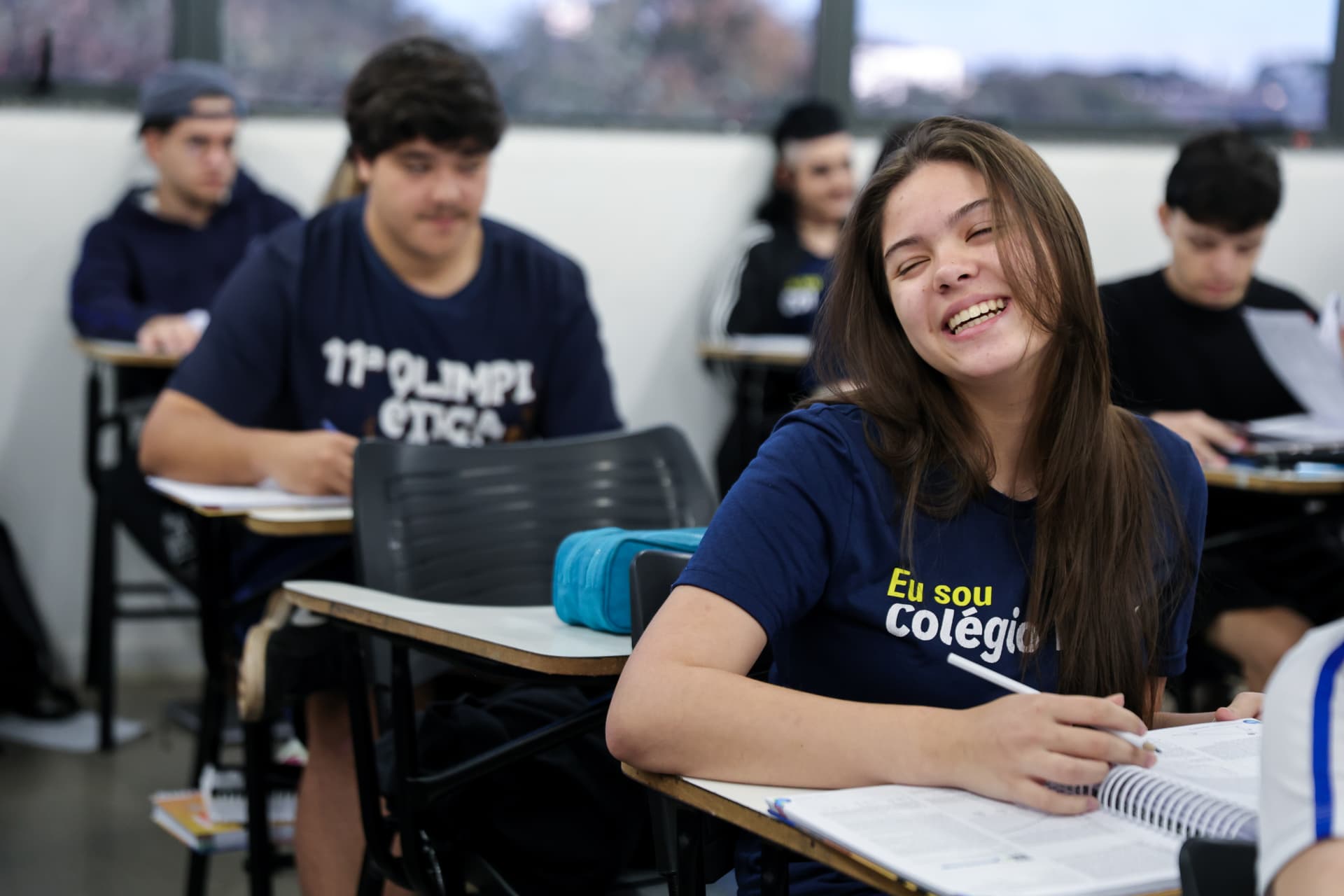 Aluna sorrindo em sala de aula no Colégio Ética